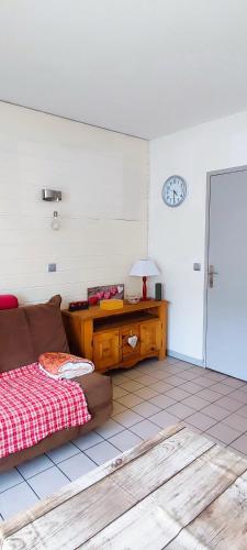 une chambre avec un canapé, une table et un réveil dans l'établissement L'Ame du chalet, à Allevard
