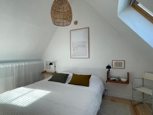 a bedroom with a white bed and a staircase at la maison Sel in Audresselles