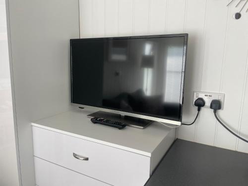 a flat screen tv sitting on top of a dresser at The Garden Room - A cosy country stay in Cornwall in Callington