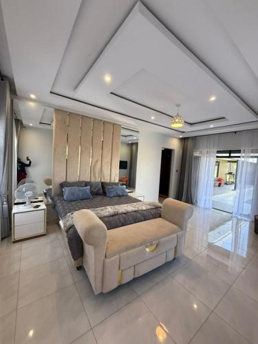 een slaapkamer met een groot bed en een bank bij Davisons Guest House in Harare