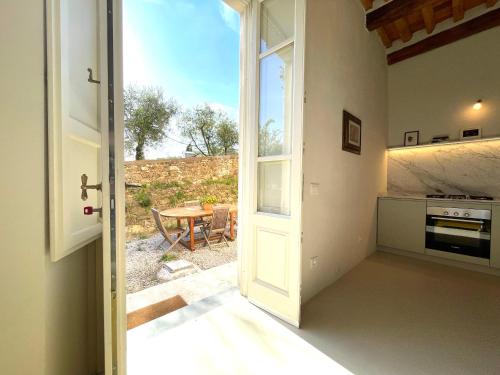 a kitchen with a door open to a patio with a table at La Bastiana in Capannori
