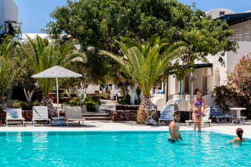 a group of people in the swimming pool at a resort at Okeanis Beach in Kamari