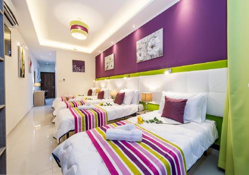 a group of three beds in a room at Bayside Apartments in St Julian's