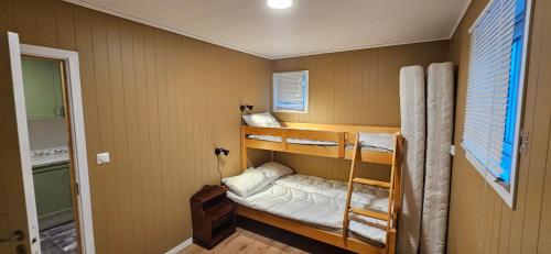 a room with two bunk beds and a window at Cabin on Åros, close to the beach in Søgne