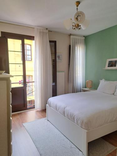 a bedroom with a large white bed and a window at Apartamento Sabugo in Avilés