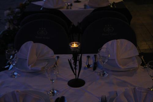 a table with a candle and wine glasses on it at Hotel Krilo in Podstrana