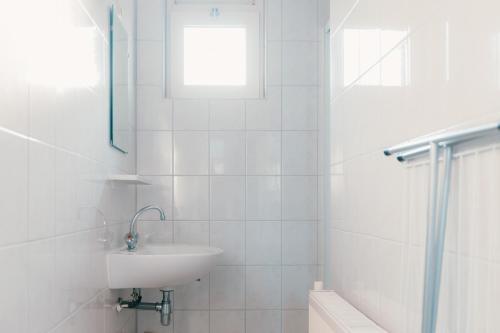 a white bathroom with a sink and a shower at Bungalow Bunckman Luxury 10 persons in Voorthuizen