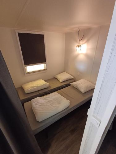 een kamer met 3 bedden en een flatscreen-tv bij Coco Sweet with sanitary in La-Roche-en-Ardenne