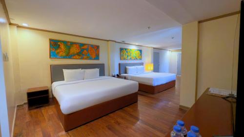 a hotel room with two beds and a bathroom at Whiterock Beach Hotel and Waterpark in Subic