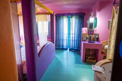 a room with a bedroom with pink and blue walls at Hotel Alma de Romero in Carranza