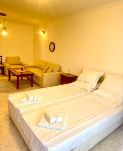 a bedroom with a large bed and a couch at Marena Studio - Santa Marina, Sozopol in Sozopol