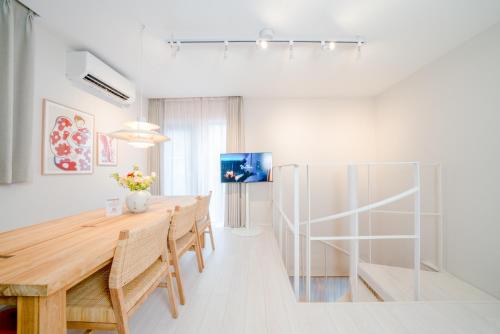a dining room with a wooden table and chairs at Ken's Place Azabu-Juban in Tokyo