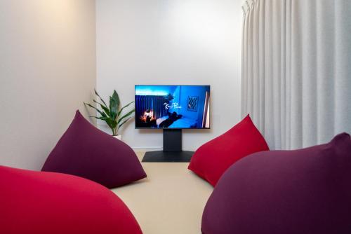 a living room with two red pillows and a television at Ken's Place Azabu-Juban in Tokyo
