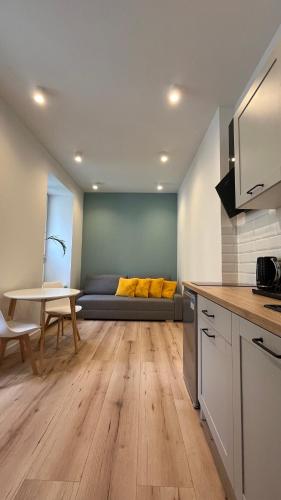 a kitchen and living room with a couch in the background at BOOGIE Home Kamienica Łódzka in Łódź