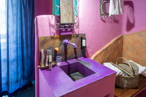 a purple sink in a bathroom with a pink wall at Hotel Alma de Romero in Carranza
