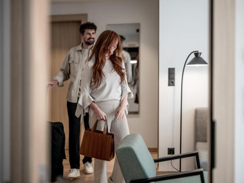a man and a woman walking through a room at Aparthotel Tante Trude in Oetz