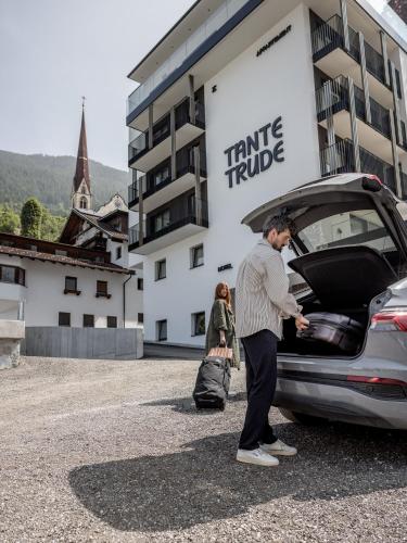 a man standing next to a car with its trunk open at Aparthotel Tante Trude in Oetz
