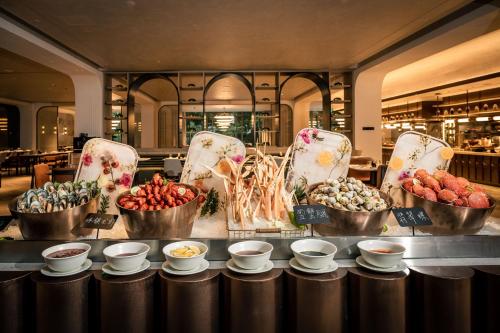 a buffet with bowls of food on a table at Crowne Plaza Hangzhou Riverside by IHG in Hangzhou