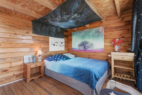 a bedroom with a bed in a log cabin at Cabane Aux Étoiles in Bargème