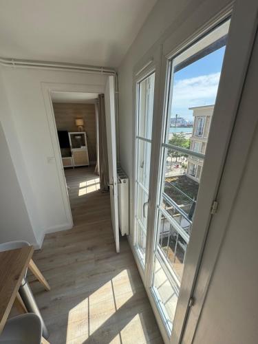 Appartement Perret - Hyper Centre في لو هافر: ممر يطل على غرفة بها نافذة