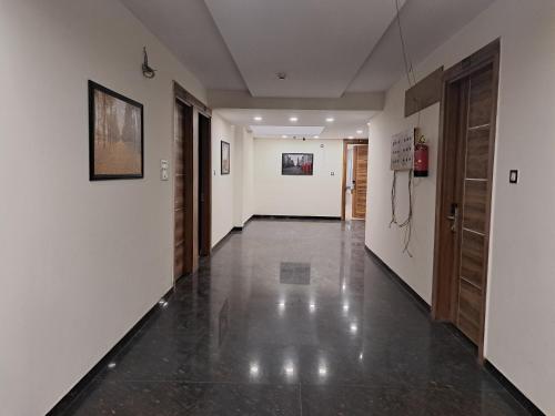 an empty hallway with white walls and black tile floors at Hotel AR Inn in New Delhi