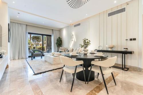 Un comedor y una sala de estar con mesa y sillas. en DAYF-FMT Fairmont Palm with Pool and Beach Access, en Dubái