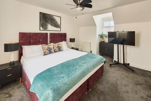 a bedroom with a large bed and a flat screen tv at Host & Stay - Blueberry House in Launceston