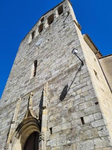 a tall brick tower with a clock on it at Petit coin de Paradis in Saint-Michel-de-Lanès