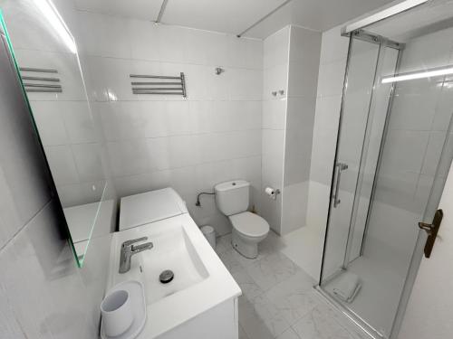een witte badkamer met toilet en douche bij Apartamento Marina Roses 4 in Roses