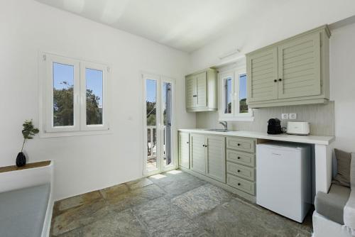 a kitchen with white cabinets and white appliances at Phaedrus Living Paros Cycladic Residences 10 in Kampos Paros