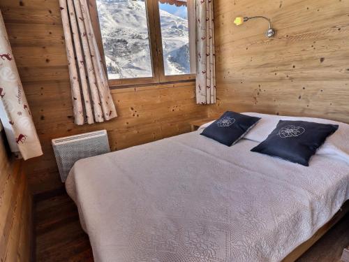 - une chambre avec un lit dans une pièce en bois dotée d'une fenêtre dans l'établissement Charmant 3 Pièces à 100m des Pistes, Idéal Famille avec Balcon, Animaux Acceptés - FR-1-182-199, à Les Allues