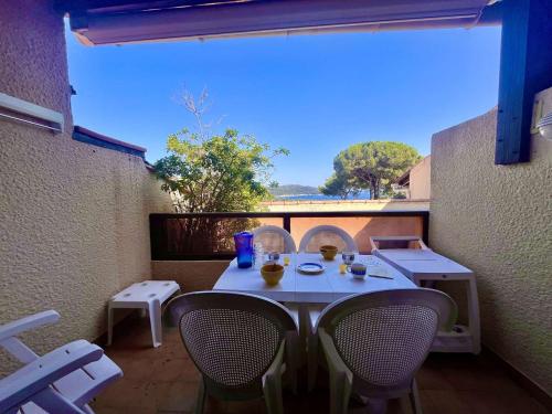une table et des chaises sur un balcon avec vue dans l'établissement Appartement 3 pièces climatisé avec piscine, tennis, parking à La Croix-Valmer - FR-1-226B-152, à La Croix-Valmer