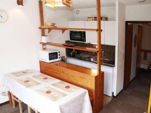 une petite cuisine avec une table et un micro-ondes dans l'établissement Studio 6 pers au pied des pistes avec balcon - Les Orres - FR-1-322-145, aux Orres