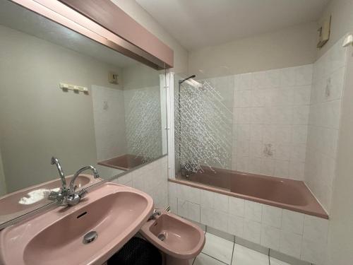 La salle de bains est pourvue d'un lavabo rose et d'une baignoire. dans l'établissement Appartement 2 étoiles avec balcon à 100m de la plage, centre-ville des Sables d'Olonne - FR-1-197-205, à Les Sables-dʼOlonne