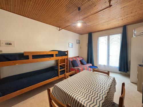 une chambre avec un lit superposé et une chaise dans l'établissement Studio simple à 2 pas de la plage, balcon, kitchenette - FR-1-197-248, à Les Sables-dʼOlonne