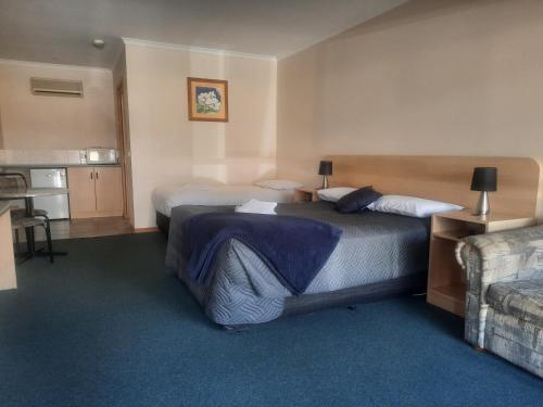 a hotel room with two beds and a couch at Arthur Phillip Motor Inn in Cowes