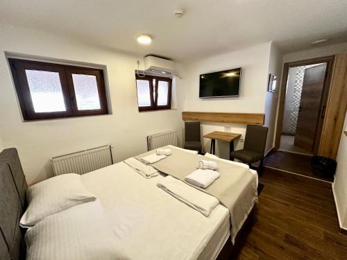 a bedroom with a bed with two towels on it at Rooms Gat in Subotica