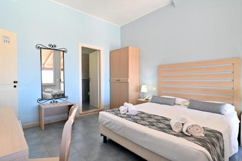 a bedroom with a large bed with towels on it at Hotel La Caletta Village in La Caletta