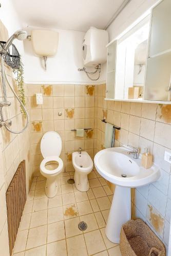 a bathroom with a toilet and a sink at Casa vacanza 'Note di mare' in Torvaianica
