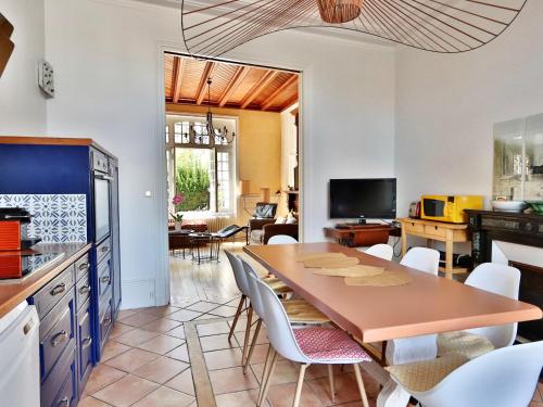une cuisine avec une table et des chaises dans une pièce dans l'établissement Maison sablaise 5 chambres, proche de la plage et du centre, tout confort inclus. - FR-1-197-447, à Les Sables-dʼOlonne