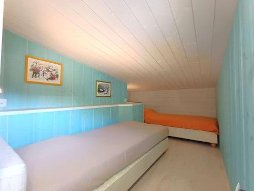 Cette petite chambre dispose d'un lit et de murs bleus. dans l'établissement Appartement 8 pers. à Saint-Lary-Soulan, Pieds des Pistes, Balcon Sud-Ouest, Équipé, Linge & Ménage - FR-1-457-169, à Saint-Lary-Soulan