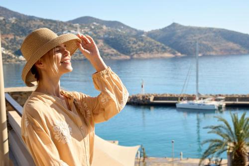 a woman wearing a hat looking at the water at Mirabello Bay Luxury Resort in Agios Nikolaos