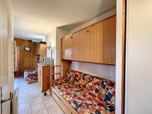 une chambre avec un lit et une cuisine avec un four micro-ondes dans l'établissement Appartement 2 pièces + coin montagne proche pistes de ski avec parking - FR-1-560-44, à Combloux