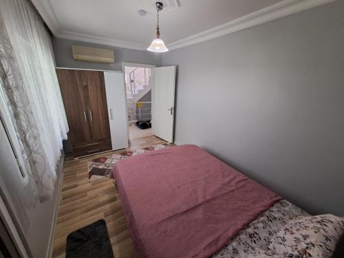 a bedroom with a bed with a purple blanket on it at Kuşadası Starfish in Kusadası
