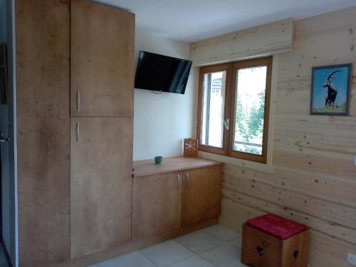 Il comprend un salon doté d'une télévision et d'une fenêtre. dans l'établissement Appartement cosy au Chinaillon, proche commerces et pistes, 4 pers, animaux admis. - FR-1-467-69, au Grand-Bornand