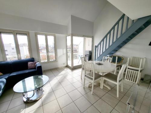 un salon avec un canapé et une table dans l'établissement Appartement T3 avec Mezzanine, Balcon et Garage au Centre des Sables-d'Olonne - FR-1-92-883, à Les Sables-dʼOlonne