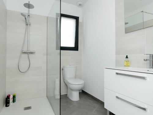 ein weißes Badezimmer mit Dusche und Toilette in der Unterkunft Maison moderne près plage Aiguillon - 2 chambres, terrasse, jardin, parking - Calme et confort - FR-1-420-63 in Arcachon