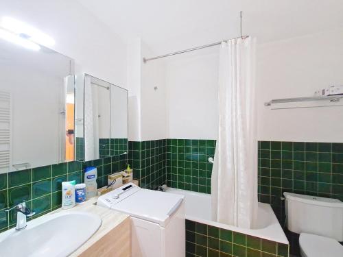 - une salle de bains verte et blanche avec lavabo et toilettes dans l'établissement Studio rénové avec terrasse sud et vue mer - FR-1-331-54, à Les Sables-dʼOlonne
