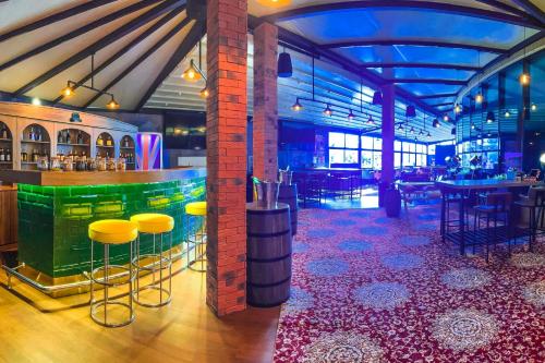 a bar in a restaurant with yellow stools at Courtyard by Marriott Riyadh Diplomatic Quarter in Riyadh