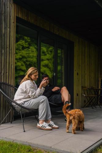 two people sitting on a bench next to a dog at Moje Miejsce Kazimierz in Kazimierz Dolny